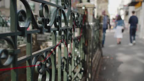 Siga-La-Toma-A-Lo-Largo-De-Barandillas-Con-Hilo-Rojo-Junto-A-La-Entrada-Del-Metro-Con-Gente-Caminando-En-París