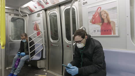 Männer,-Die-Während-Des-Coronavirus-Ausbruchs-In-Der-U-Bahn-Mit-Gesichtsmasken-Und-Handschuhen-Auf-Ihre-Telefone-Schauen