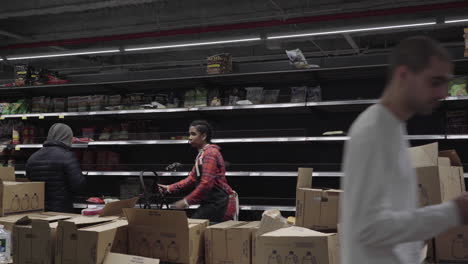 Shoppers-in-front-of-emptied-chips-and-snacks-shelves-at-wholefoods