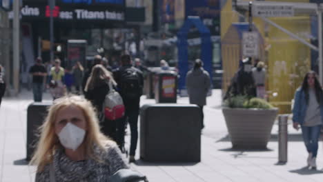 Dos-Mujeres-Caminando-Con-Mascarilla-En-Time-Square-Con-Multitud