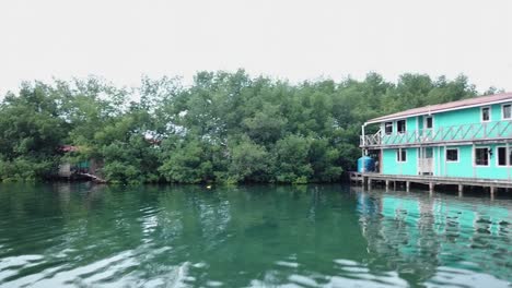 Luftaufnahme-Von-Menschen,-Die-Von-Einem-Bungalow-In-Panama-Aus-Ins-Meer-Springen