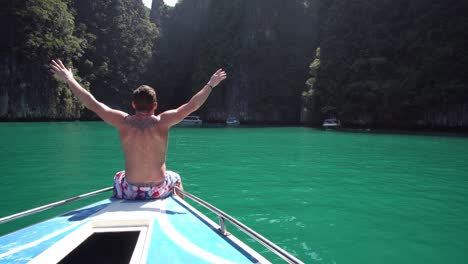 Macho-Joven-Disfrutando-De-La-Vista-De-La-Exótica-Laguna-Tropical-Desde-La-Proa-Del-Barco