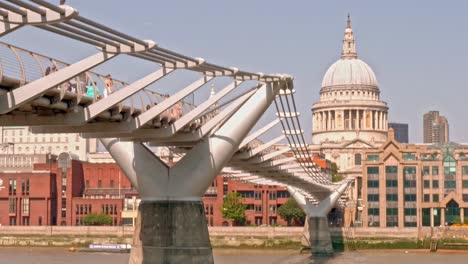 A-side-view-of-architectural-structure-of-Millennium-Bridge-London-with-St-Pauls-Cathedral-at-the-background,-Great-Britain-UK---vertical-panning-shot