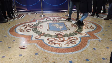 Milano,-Italy---December-30th,-2018:-Young-girl-spinning-on-the-bull-for-luck-at-the-Galleria-Vittorio-Emanuele-in-Milano,-Italy