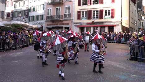 Solothurn,-Switzerland---March-03th,-2019:-A-musical-carnivals-club-with-huge-hats-and-garland-playing-brass-instruments-while-walking-the-carnival-deal