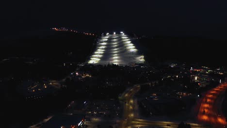 Aerial-view-of-the-Levi-town-and-slopes,-night-in-Lapland---reverse,-drone-shot