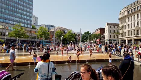 Multitud-De-Personas-Disfrutando-Del-Verano-En-La-Fuente-De-Agua-En-La-Antigua-Plaza-Del-Mercado-En-Nottingham,-Inglaterra,-Reino-Unido.