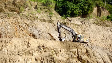 Backhoe-Digging-Sand-And-Gravel-In-A-Quarrying-Site---dolly-in-shot