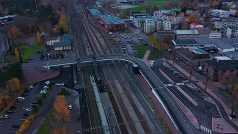 Luftaufnahme-Eines-Zuges,-Der-An-Einem-Bahnhof-Ankommt,-Regnerisch,-Herbsttag---Umlaufbahn,-Drohnenaufnahme