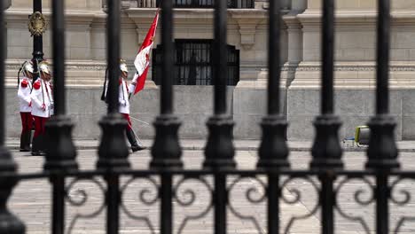 Guardias-Del-Palacio-Presidencial-En-Perú-Marchando,-Vistos-A-Través-De-Las-Puertas.