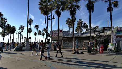 Gente-Enmascarada-Entrando-Al-Mundialmente-Famoso-Paseo-Marítimo-Y-A-La-Playa-En-Un-Día-Soleado,-En-Venecia,-Los-Ángeles,-California,-Estados-Unidos---Vista-Fija