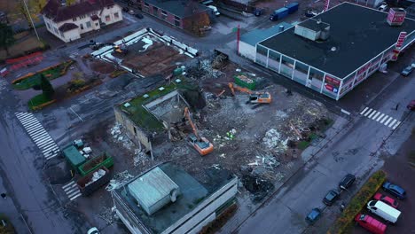 Vista-Aérea-Alrededor-De-Excavadoras-Que-Destruyen-Un-Edificio-Urbano,-Día-Sombrío---órbita,-Disparo-De-Drones