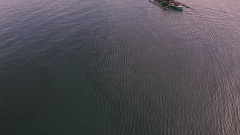 Fishermen-In-A-Fishing-Boat-Sailing-On-The-Deep-Blue-Sea-In-Siargao,-Philippines---aerial-drone