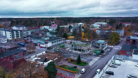 Aerial-drone-view-towards-diggers-dismantling-a-urban-city-structure,-dark-day