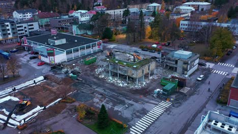 Vista-Aérea-Acercándose-A-Excavadoras-Que-Destruyen-Un-Edificio-Urbano---Dando-Vueltas,-Disparo-De-Drones