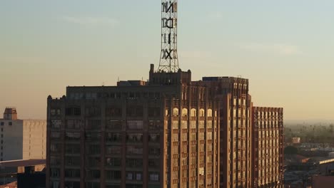 Slow-rising-and-tilt-aerial-shot-of-historic-Bendix-Building-and-traffic-on-a-highway-in-the-background