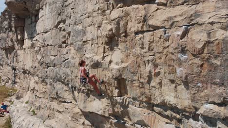 Young-Woman-Struggling-to-Climb-Rock-and-Giving-Up