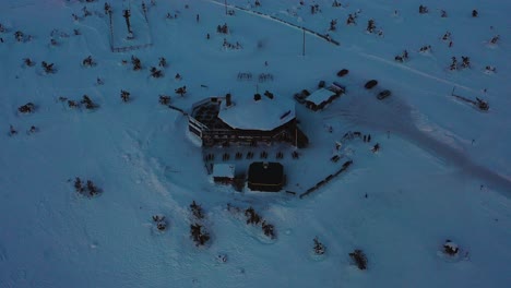 Vista-Aérea-Del-Restaurante-Tuikku-En-La-Cima-Del-Levi,-En-La-Sombría-Laponia---Inclinación,-Disparo-De-Drones