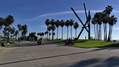 People-enjoying-a-bright-quiet-day-on-the-Venice-Beach-Boardwalk-in-Los-Angeles,-California,-USA