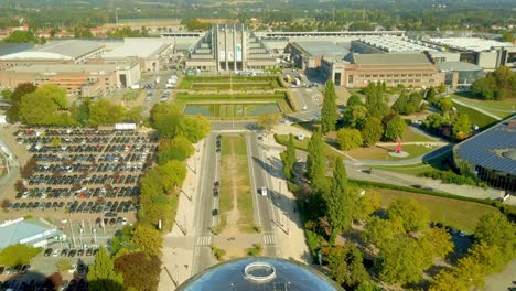 Toma-Aérea-Desde-Lo-Alto-Del-Atomium-Que-Revela-El-Palacio-Centenario-En-La-Place-De-Bélgica,-Sede-Del-Centro-De-Exposiciones-Expo-De-Bruselas-En-Bélgica