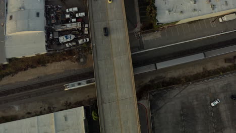 Vista-Aérea-Por-Drones-Del-Tren-Que-Pasa-Por-Debajo-Del-Paso-Elevado-De-La-Autopista