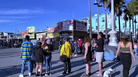 Personas-Con-Máscaras-Y-Reunidas-Para-Ver-Una-Actuación-En-El-Paseo-Marítimo-De-Venice-Beach-Durante-El-Covid-19-En-Los-ángeles,-California,-Estados-Unidos