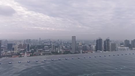 Cityscape-View-From-Infinity-Pool-Pan-Right-To-Tourists-At-Marina-Bay-Sands-Hotel-In-Singapore