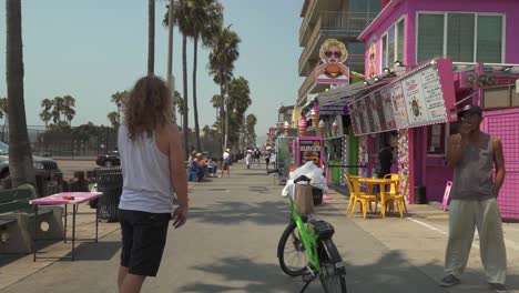 Toma-Cinematográfica-En-Cámara-Lenta-De-Un-Hombre-Caucásico-En-Patineta-En-Venice-Beach,-California.