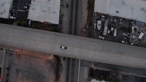 Toma-Aérea-De-Un-Dron-Del-Paso-Elevado-De-La-Autopista-Con-Un-Coche-De-Policía-Pasando