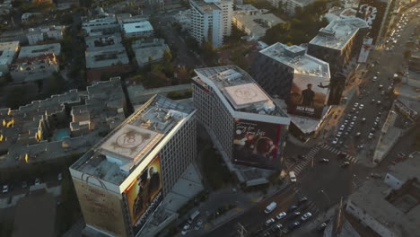 Vista-Aérea-Del-Tráfico-Nocturno-De-Sunset-Boulevard,-Edificios-De-West-Hollywood-En-La-Hora-Dorada,-Revelando-Un-Disparo-De-Drone