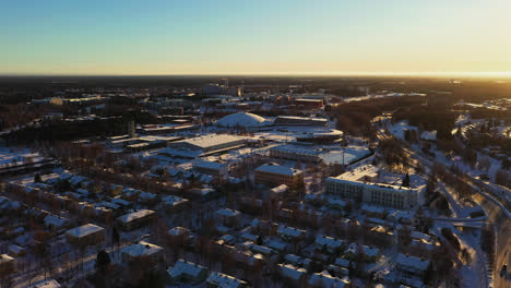 Vista-Aérea-Del-Estadio-Deportivo-De-Ouluhalli,-Amanecer-En-Oulu---Seguimiento,-Disparo-Con-Drones