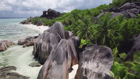 FPV-Drohne-Schoss-Durch-Große-Granitblöcke-Und-Palmen-Am-Strand-Von-Anse-Source-D&#39;Argent,-La-Digue,-Seychellen