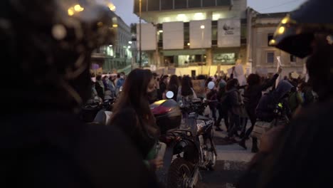 Policemen-wearing-helmets-are-looking-at-a-crowd-of-women-who-is-marching-during-a-protest-in-the-International-Women's-day-in-Quito,-Ecuador