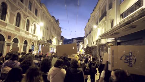 Women-march-while-holding-up-signs-with-protest-phrases-in-Quito,-Ecuador-during-the-International-Women's-day,-They-are-wearing-masks-due-to-covid-19-#8M