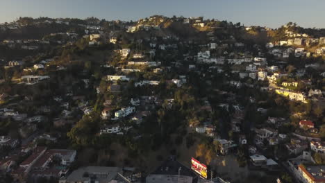 Vista-Aérea-De-Las-Colinas-De-Hollywood-Sobre-El-Bulevar-Sunset-Bajo-La-Luz-Del-Sol-De-La-Hora-Dorada,-Revelando-Un-Disparo-Inclinado-Hacia-Arriba-Con-Un-Dron