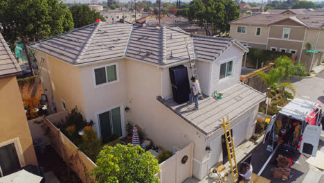 Worker-Stacking-Solar-Panel-On-The-Roof-Of-A-Contemporary-House-In-Los-Angeles,-California-On-A-Sunny-Day