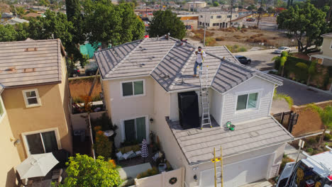 Trabajadores-Subiendo-Una-Escalera-Al-Techo-De-Una-Casa-Contemporánea-En-Los-Ángeles-Para-Instalar-Paneles-Solares,-California,-En-Un-Día-Soleado