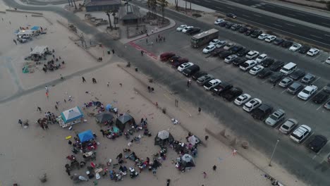 Luftaufnahme-Von-Familientreffen-Am-Huntington-State-Beach,-Kalifornien,-USA-Und-Dämmerungsverkehr-Auf-Dem-Pacific-Coast-Highway,-Drohnenaufnahme