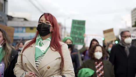 Frauen-Marschieren-Und-Singen,-Während-Sie-Während-Des-Internationalen-Frauentags-In-Quito,-Ecuador,-Schilder-Und-Fahnen-Mit-Protestsätzen-Hochhalten