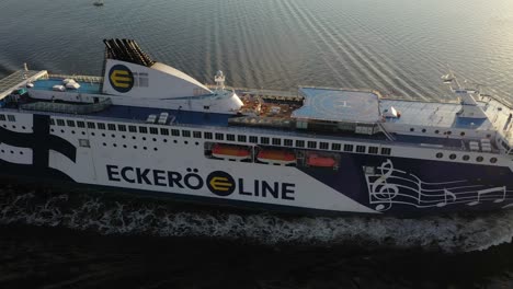Aerial-view-following-the-Eckero-line-cruiseliner-ship,-moving-towards-the-Helsinki-cityscape---pan,-drone-shot