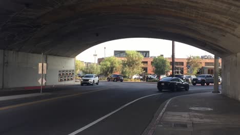 Traffic-driving-through-the-4th-Street-bridge-in-Los-Angeles,-California-on-a-sunny-summer-day,-wide-handheld-shot