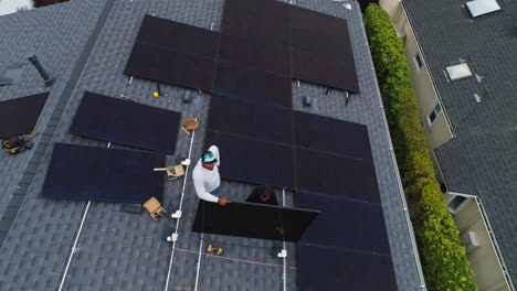 Vista-De-Pájaro-De-Los-Trabajadores-Varones-Instalando-Paneles-Solares-En-El-Techo-De-La-Casa