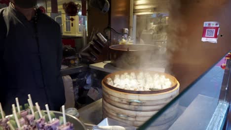 Hombre-Mostrando-Comida-Disponible-En-El-Mercado-De-Comida-Callejera-En-Beijing,-Dashilar,-China