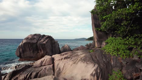 Drone-FPV-Cerca-De-Rocas-De-Granito-Desde-Pointe-Cap-Barbi-Hasta-Anse-Sever,-Isla-De-La-Digue,-Seychelles