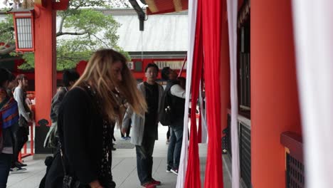 Tourist-girl-trying-to-pray-and-ringing-the-bell-at-the-temple-in-kyoto