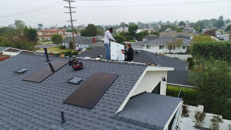 Dos-Trabajadores-Instalan-Paneles-Solares-En-El-Techo-De-Una-Casa-Residencial.