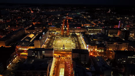 Volando-Hacia-La-Plaza-Del-Mercado-Iluminada-Por-La-Noche,-Invierno-En-Vaasa,-Finlandia---Vista-Aérea