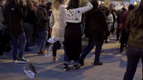 Eine-Frau-Hält-Ein-Schild-Mit-Einer-Botschaft-Hoch-Und-Trägt-Außerdem-Ein-T-Shirt-Mit-Einem-Spruch,-Der-Der-Polizei-Während-Des-Marsches-Zum-Internationalen-Frauentag-Gewidmet-Ist