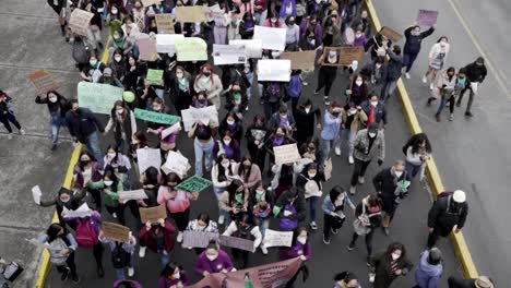 Thousands-of-women-march-while-holding-up-signs-of-protest-during-the-International-Women's-day-in-Quito,-Ecuador