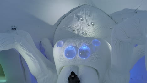 Kids-Having-Fun-with-Huge-Scary-Spider-Snow-Sculpture,-Snow-Village,-Lapland,-Tilt-Down